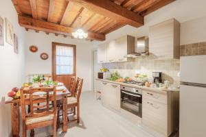 a kitchen with a table and a dining room at La Corte in Vicopisano