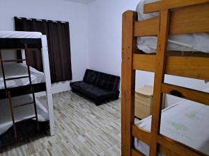 a room with two bunk beds and a couch at Casa Grande na zona sul in Sao Paulo
