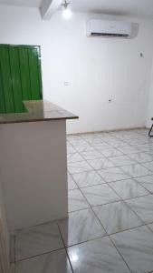 an empty room with a counter and a green door at Quarto 1 in Várzea Grande