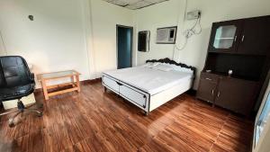 a bedroom with a bed and a desk and a tv at Celebrations Place Farmhouse in Gurgaon