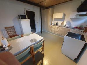 a kitchen with a table and a kitchen with a refrigerator at Nordborg Apartment Hejnsvi in Hejnsvig