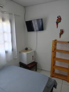 a bedroom with a bed and a tv on the wall at Belo Suítes in Ubatuba +20 photos