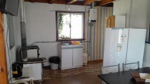 una cucina con 2 frigoriferi bianchi e una finestra di Cabaña Vista Queule a Queule