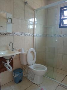 a bathroom with a toilet and a sink and a shower at Belo Suítes in Ubatuba