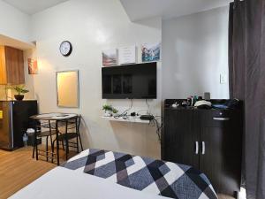 una stanza con un letto e una TV su una parete di The Loop 2203 - Goff's Place a Cagayan de Oro