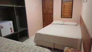 a small bedroom with two beds and a window at pousada malva branca in Piranhas