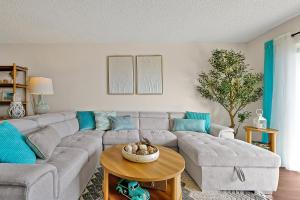 un soggiorno con un divano grigio e un tavolo di Direct Oceanfront Condo with amazing Views near Cocoa Beach a Cocoa Beach
