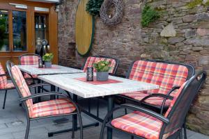 a group of tables and chairs on a patio at Wein- und Gästehaus M. Bai in Mesenich