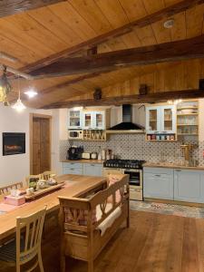 a large kitchen with a wooden table and a counter at Chalupa JFD, Josefův Důl in Josefuv dul