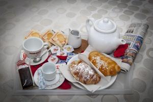 a tray with a tea kettle and pastries on it at Napoli Garibaldi Square in Naples