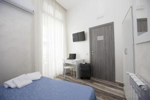 a bedroom with a bed and a desk and a door at Napoli Garibaldi Square in Naples
