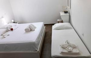 a bedroom with two beds with towels and bows at Sweet Home Nikorenia 1 in Krotiri