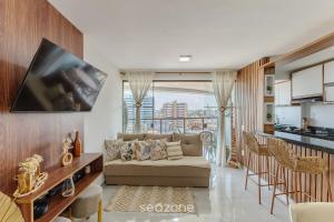 a living room with a couch and a kitchen at Prédio com Piscina a 300m da Praia em Ilhéus - MMD in Pontal de São João da Barra