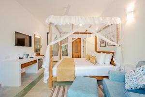 a bedroom with a canopy bed and a couch at Aurora in Unawatuna