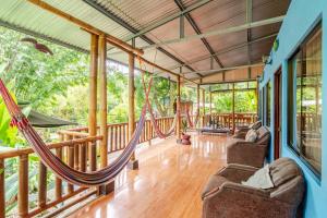 a room with hammocks on a porch at El Manantial de Corcovado in Dos Brazos