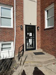 una puerta negra de un edificio de ladrillo al lado de un edificio en Riverside Retreat Apartments, en Evansville