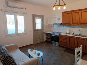 a living room with a couch and a kitchen at Sweet Home Nikorenia 1 in Krotiri