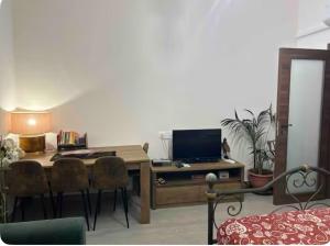 a living room with a desk with a television and chairs at Stanza matrimoniale x2 in Legnano