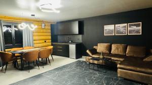 Una sala de estar con un sofá y una mesa y una cocina. en Rodnei Retreat, en Borşa