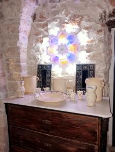 a table with vases and a plate on top of it at Palazzo Rizzi Dimora dei Templari in Bitetto +51 photos