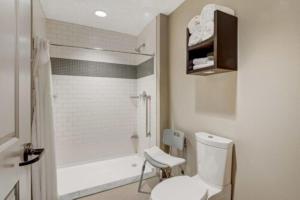a bathroom with a white toilet and a shower at Staybridge Suites Baltimore - Inner Harbor by IHG in Baltimore