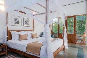 a bedroom with a white bed with a canopy at Aurora in Unawatuna +37 photos