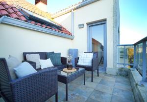 a patio with wicker chairs and a table at GALIHOST - Apartamento con terraza en Vilagarcía de Arousa in Vilagarcia de Arousa