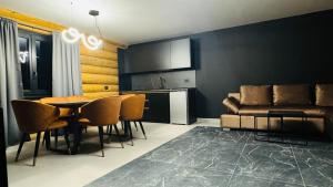 a living room with a table and chairs and a couch at Rodnei Retreat & Spa in Borşa