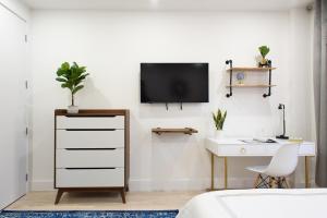 ニューヨークにある1597-8 Luxury STUDIO Upper East Side W&Dの机と壁掛けテレビのある寝室