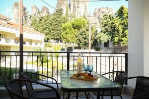 a table with a plate of food on a balcony at Aether Home with view in Kalabaka