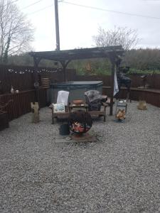 a patio with a gazebo and chairs in a yard at The Stables in Gloucestershire
