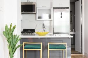 a kitchen with white cabinets and green stools at 1597-PHS New 1BR-2bath PH Duplex Outdoor Deck in New York