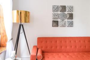 a living room with a orange couch and a lamp at 1597-PHS New 1BR-2bath PH Duplex Outdoor Deck in New York