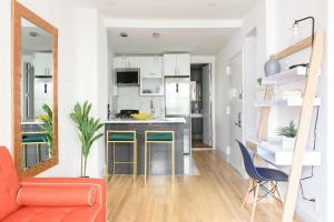 a living room with a orange couch and a kitchen at 1597-PHS New 1BR-2bath PH Duplex Outdoor Deck in New York +30 photos