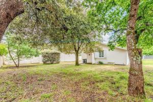 a white house with trees in the yard at Maison charmante à Soulac-sur-Mer avec jardin clôturé in Soulac-sur-Mer