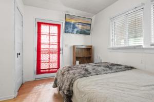 a bedroom with a bed and a red door at Hideaway Cabin - Cozy romantic cabin perfect for couples in Big Bear City