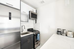a kitchen with a sink and a stove top oven at 1597-PHN PH Duplex -Private Outdoor 2bath in New York