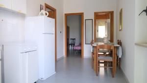 a kitchen with a table and a white refrigerator at Santa Lucia-Park Coppa della Nuvola in Peschici