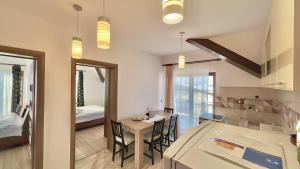 Una cocina y un comedor con mesa y sillas. en Apartamente Simona Brasov, en Brasov