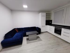 un soggiorno con divano blu in cucina di Apartment Halova a Bratislava