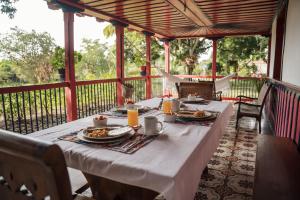 a table with plates of food on a porch at Finca Hotel El Balso Armenia, Quindío in Armenia