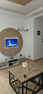 a living room with a table and a tv on a wall at Samy's Luxury Apartments in Hammamet