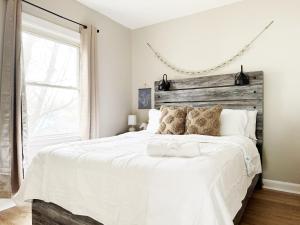 a bedroom with a white bed with a wooden headboard at Spring Street Suites in Evansville
