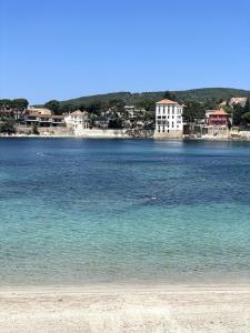 Blick auf einen Strand mit Gebäuden im Hintergrund in der Unterkunft Casa Del Mar, en plein centre ville! in Bandol