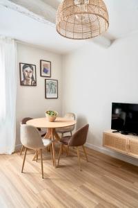 ein Esszimmer mit Tisch und Stühlen und einem Fernseher in der Unterkunft Casa Del Mar, en plein centre ville! in Bandol