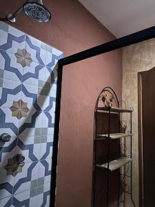 a bathroom with a blue and white tile wall and a shelf at Casa la Roca Valladolid in Valladolid