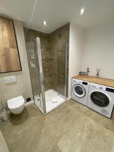 a bathroom with a shower and a washing machine at Kleine Auszeit in Bad Driburg