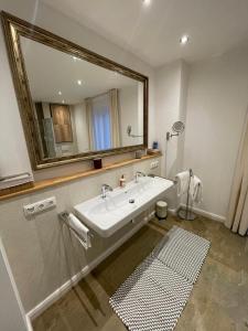 a bathroom with a sink and a large mirror at Kleine Auszeit in Bad Driburg