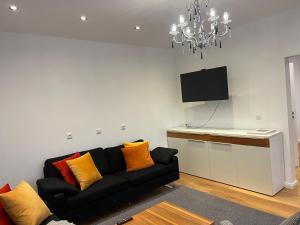 a living room with a couch and a flat screen tv at Kleine Auszeit in Bad Driburg +8 photos