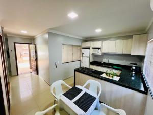a kitchen with a table and chairs in a room at Moderno Sobrado Climatizado com Ar Quente e Frio in Cascavel